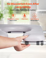Hand holding a cushioned raised toilet seat with features listed on a blurred background that includes foam padding, wide seat and waterproof leather
